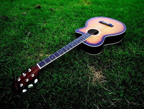 在床上一个小男孩旁边有一个吉他的图片